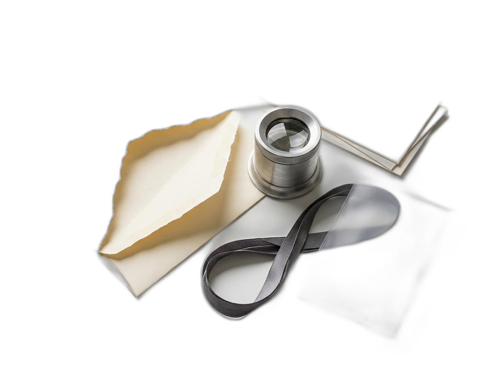 Een geopende envelop, metalen loep, blanco headerkaarten, linkstrook en afgesloten bijlagehoes
